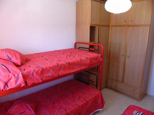 マタラスカニャスにあるApartamento Virgen de la Sierraの二段ベッド2台とキャビネットが備わる客室です。