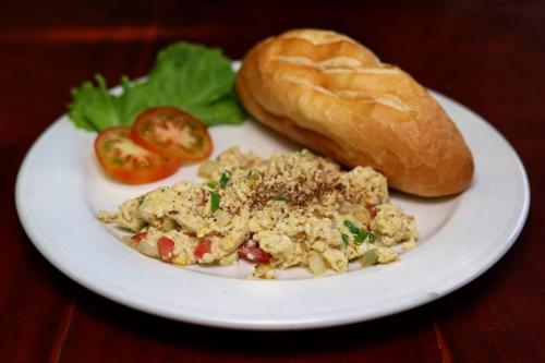 a plate of food with a sandwich and a bread at Gia Thanh Phu Quoc Guest House in Phu Quoc