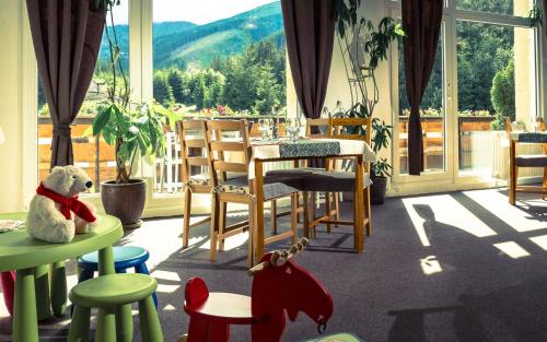 a restaurant with a table and chairs and a teddy bear at Hotel Liptov in Demanovska Dolina