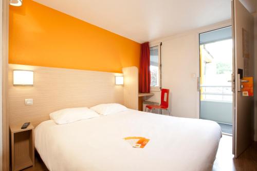 a hotel room with a large white bed and a window at Première Classe Toulouse Nord - L'Union in LʼUnion