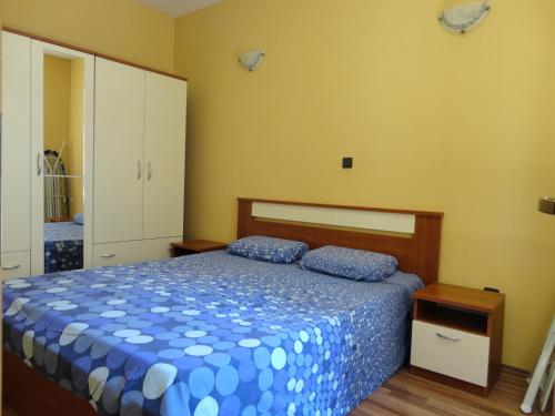 a bedroom with a bed with a blue comforter at Apartment Ivana in Biograd na Moru