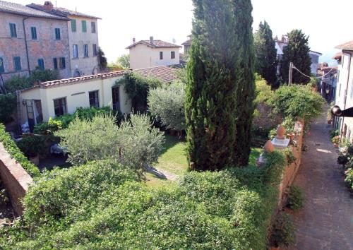 a garden with trees and bushes and a building at antica casa "le rondini" in Borgo a Buggiano