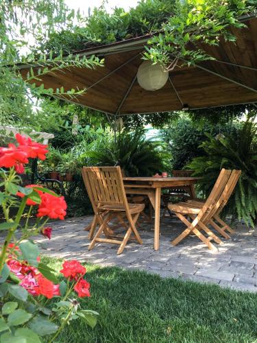a wooden table and two chairs under a wooden umbrella at Garden House in Timişoara