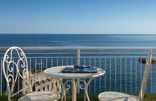 a table and chairs on a balcony with the ocean at Hotel Club Due Torri in Maiori