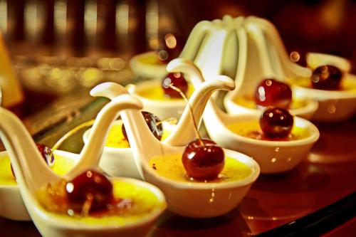 a bunch of dessert dishes with cherries in them at Amman International Hotel in Amman