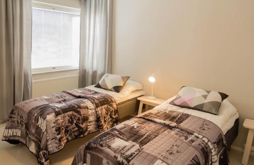 two beds in a room with a window at Apartment City-Pekka in Rovaniemi