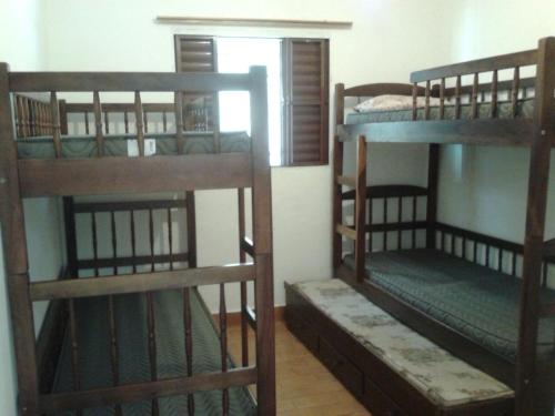Zimmer mit 3 Etagenbetten in einem Zimmer in der Unterkunft Casa em Caraguatatuba in Caraguatatuba