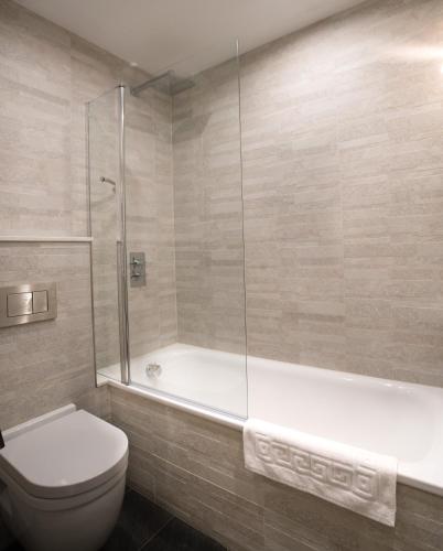 a bathroom with a tub and a toilet and a shower at The Coffee House Hotel in Aberdeen