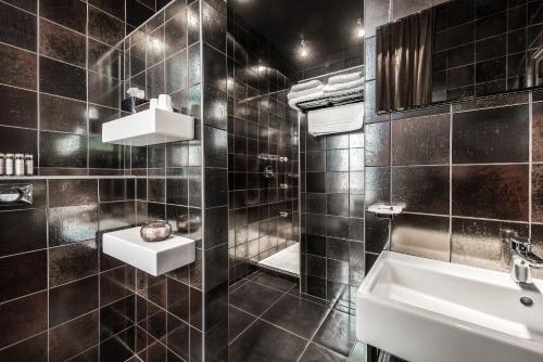 a bathroom with a sink, mirror, and bathtub at Main Street Hotel in Ieper
