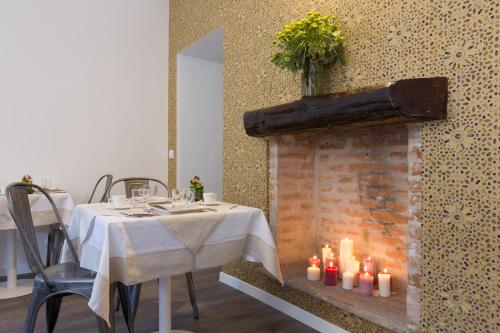 a dining room with a table and a fireplace with candles at Ai Suma Hotel in Milan