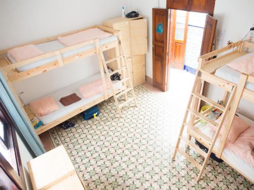 a small room with a bunk bed and a desk at Lua Lua Hostel Las Palmas in Las Palmas de Gran Canaria