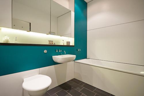 a bathroom with a toilet and a sink and a mirror at Kaywana Hall in Dartmouth