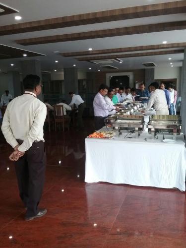 a group of people standing around a table with food at Hotel Abhilasha in Giriak