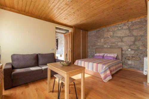 a living room with a bed and a couch at Casa da Lagiela rural senses in Fafe