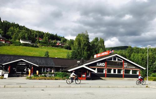 Dos personas montando en bicicleta delante de un restaurante koco en Sødorp Gjestgivergård Motell, en Vinstra