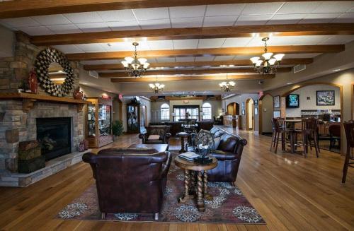 a living room with leather furniture and a fireplace at Marv Herzog Hotel in Frankenmuth