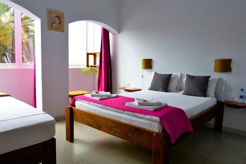 a bedroom with a large bed with a pink blanket at kasa Tambla in Ponta do Sol