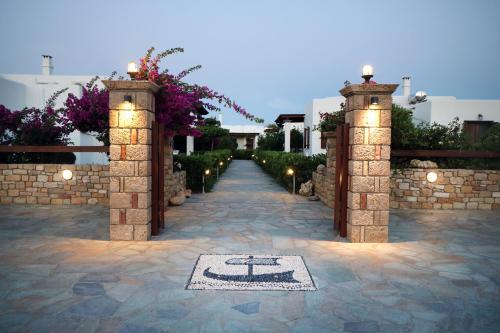 a stone pathway with two archways with flowers at Anemonisia Deluxe Apartments in Skiros