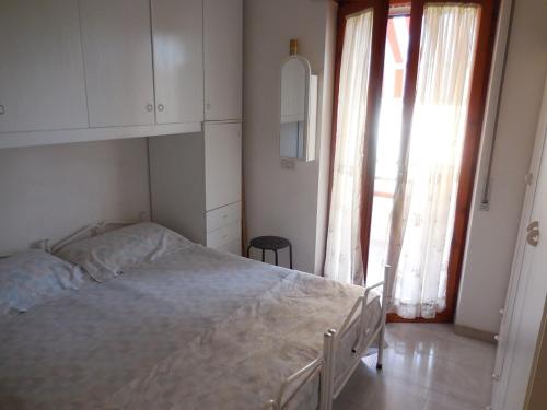 - une chambre avec un grand lit et une grande fenêtre dans l'établissement Appartamento Monticello Vista Mare, à Scalea