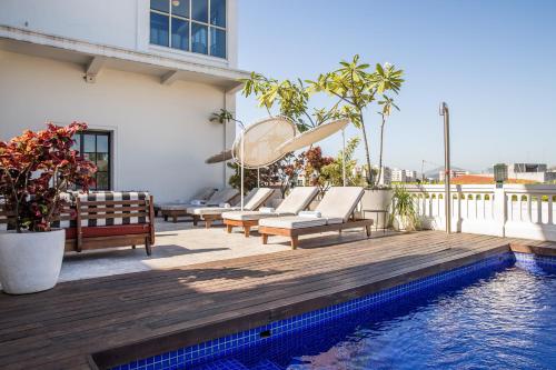 een terras met ligstoelen en een zwembad bij American Trade Hotel in Panama-Stad