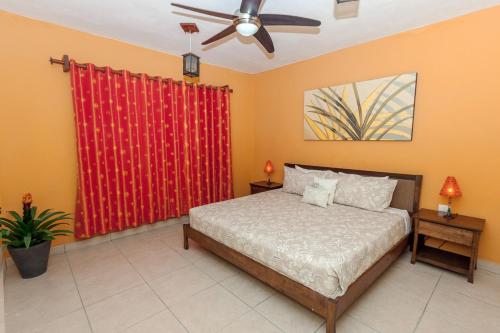 1 dormitorio con cama y cortina roja en Penthouse Jazmin - Downtown Playa del Carmen - At Margaritas II Condos, en Playa del Carmen
