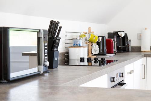 uma cozinha com um balcão com electrodomésticos em Badgers Den em Linlithgow