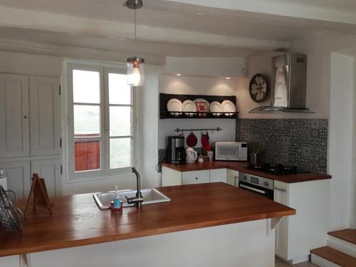 a kitchen with a wooden counter top and a sink at Gîte du Besset in Pradelles