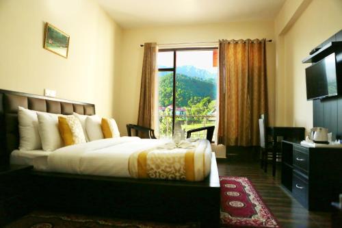 a hotel room with a bed and a window at Chimbalhar Heights in Pālampur