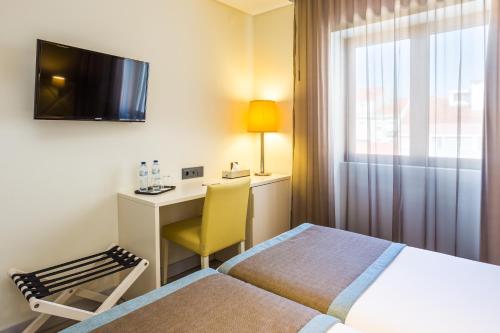 Televiisor ja/või meelelahutuskeskus majutusasutuses Empire Lisbon Hotel