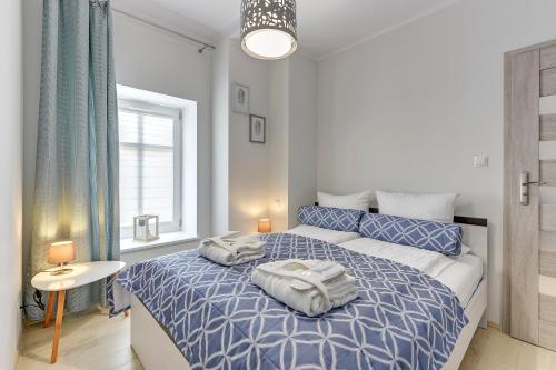a bedroom with a blue bed with two towels on it at Lion Apartments - Haffnera 19 in Sopot