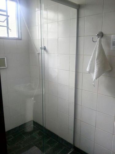 a shower stall with a glass door with a towel at Hotel JF in Pirassununga