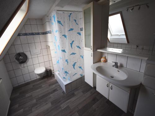 a bathroom with a sink and a shower curtain with dolphins at AB Apartment Objekt 76 in Fellbach