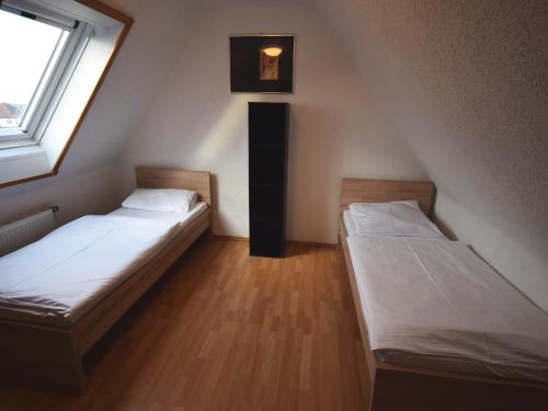 two beds in a small room with a window at AB Apartment Objekt 76 in Fellbach