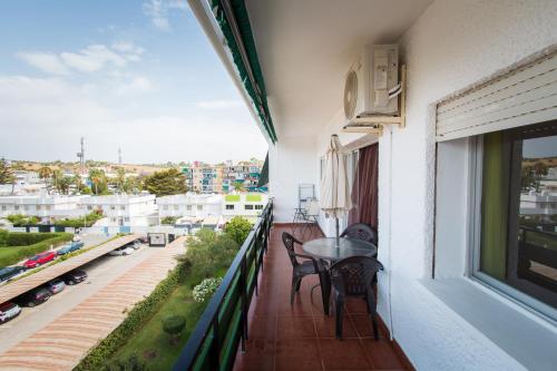 トレモリノスにあるHolidays2Torremolinos Apartamento de 3 dormitorios con terraza y piscina comunitariaの市街の景色を望むバルコニー(テーブル、椅子付)