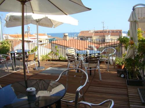 a patio area with chairs, tables and umbrellas at Hostal Platja in Cambrils