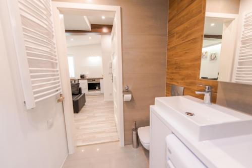 スカビナにあるBako Apartament DeLuXのバスルーム(白い洗面台、トイレ付)