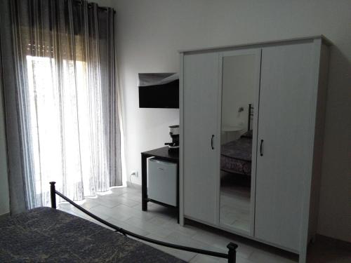 - une chambre dotée d'une grande armoire blanche avec un miroir dans l'établissement Caltagirone Casa Serena, à Caltagirone
