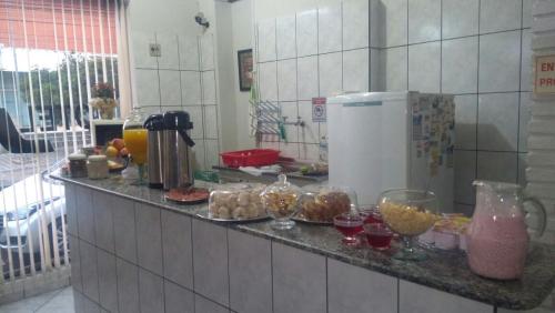 una barra de cocina con tazones de comida y copas de vino en Hotel JF, en Pirassununga