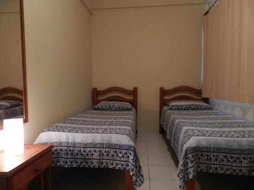 Aparthotel Eporedia في ناتال: غرفة نوم بسريرين وخزانة فيها