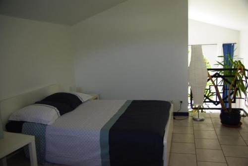 ヴァロン・ポン・ダルクにあるla maison bleueの植物のある部屋のベッド1台が備わるベッドルーム1室を利用します。