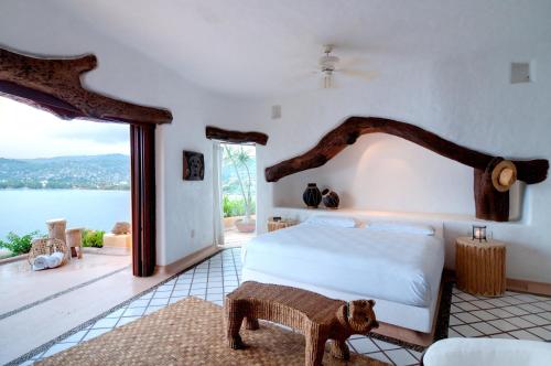 a bedroom with a bed and a view of the water at Espuma Hotel - Adults Only in Zihuatanejo