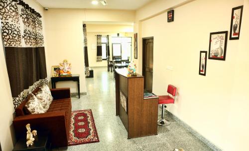 a living room with a couch and a red chair at Chimbalhar Heights in Pālampur
