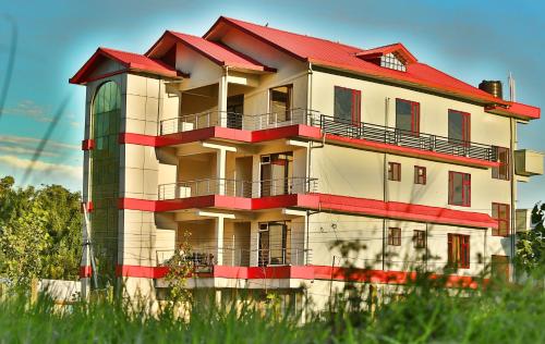 a building with a red roof on top of it at Chimbalhar Heights in Pālampur