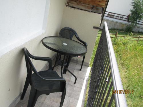 a table and two chairs sitting on a balcony at Guest House Baranin Pitomine in Žabljak