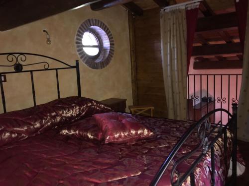 a bedroom with a bed with a red comforter and a window at Casa etna in Bronte