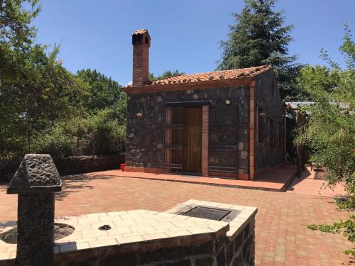 a small stone building with a brick patio at Casa etna in Bronte