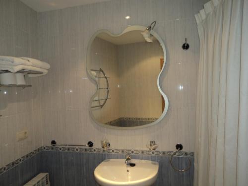 a bathroom with a sink and a mirror on the wall at Hotel de Apartamentos Casa Rosendo in Cangas del Narcea
