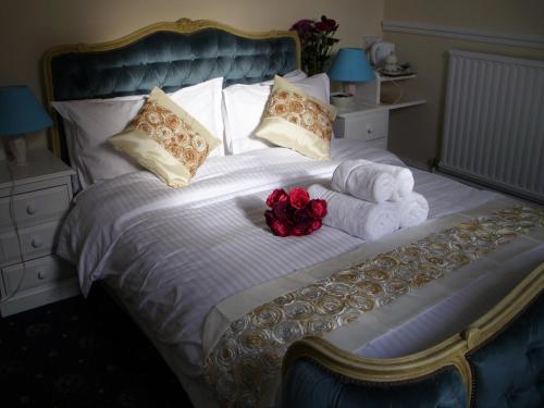 um quarto com uma cama com toalhas e flores em Estoril em Penzance