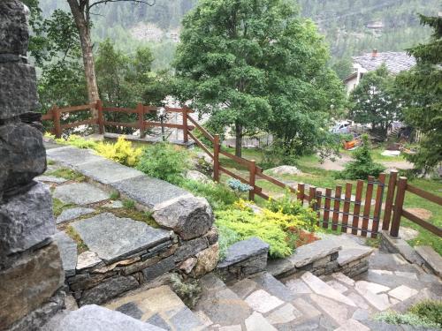 a garden with a wooden fence and a stone path at CHALET A CERESOLE REALE nel Parco Gran Paradiso in Ceresole Reale