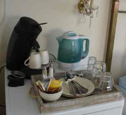 a counter top with a teapot and dishes on it at Logement Brocante in De Koog